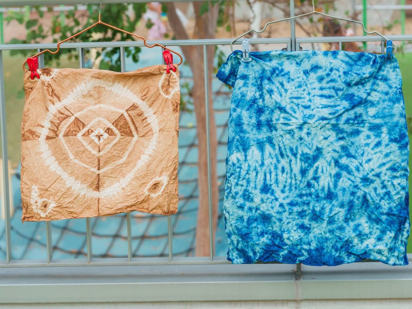 Shibori-dyed cloth drying on a rail, indigo and resist-white